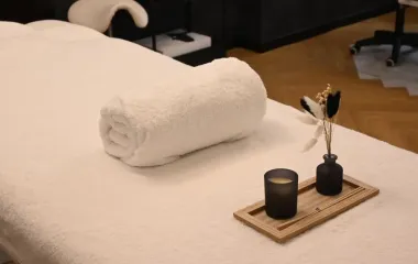 관리 침대 위에 놓인 말린 수건과 캔들